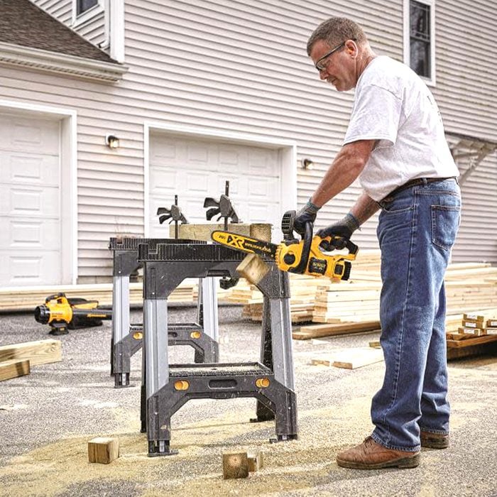 man cutting wood with chainsaw