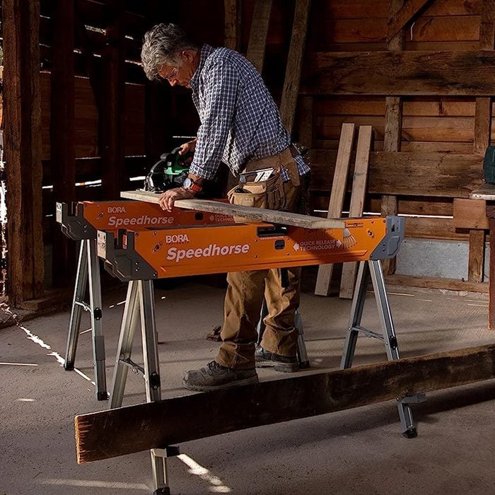 man using cutter and saw horse